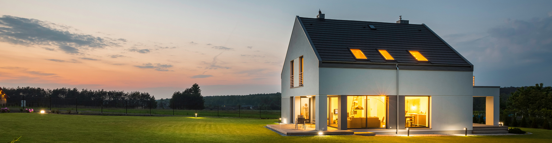 Panoramic photo of modern house with outdoor and indoor lighting, at night